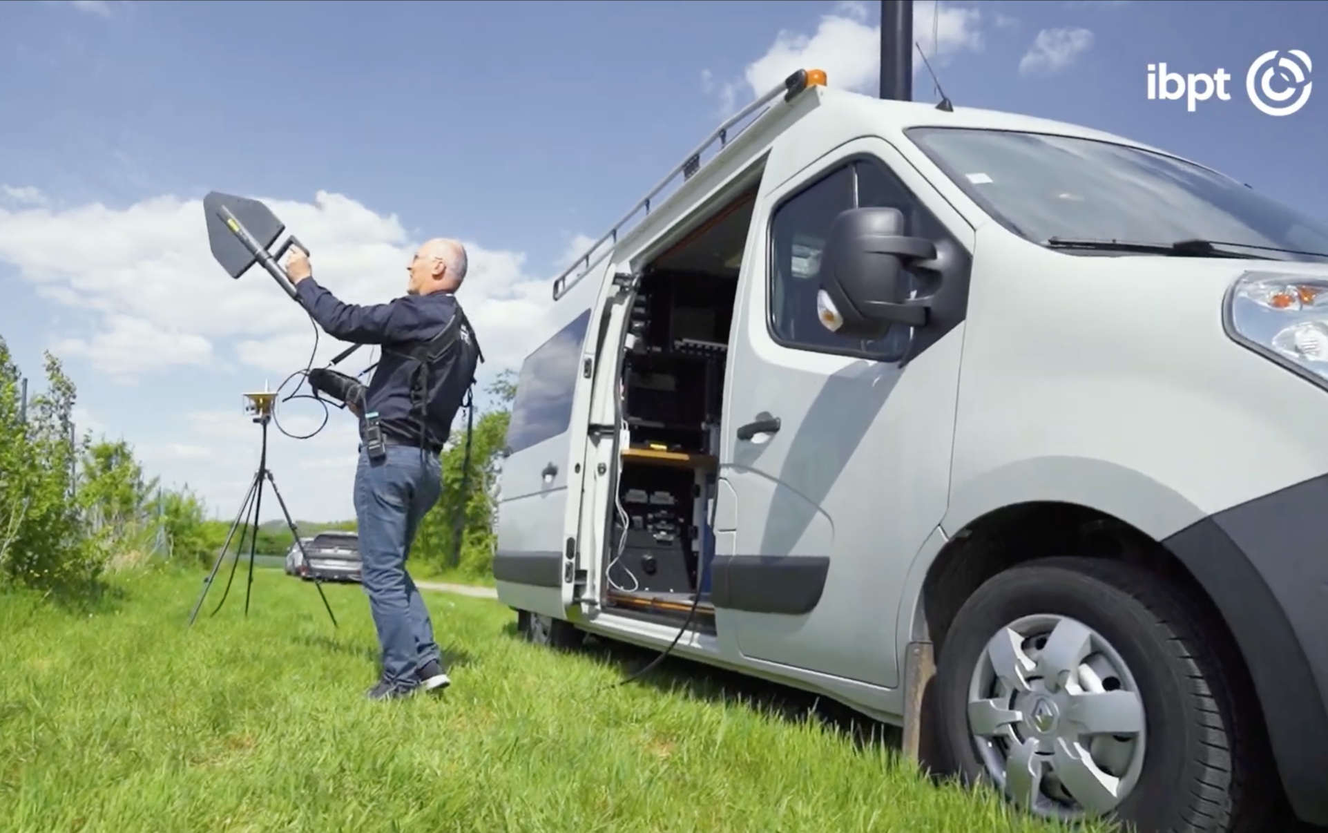 Foto van een medewerker van het BIPT naast zijn bestelwagen terwijl hij spectrumcontroleapparatuur gebruikt
