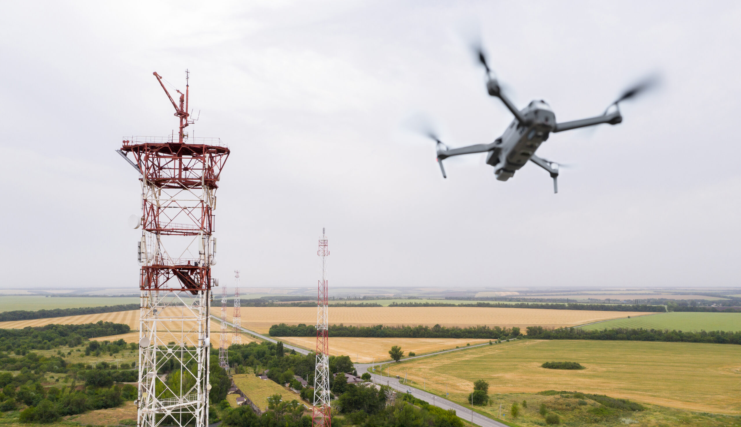 Foto van een drone in vlucht in de buurt van een toren met radiovoorzieningen 